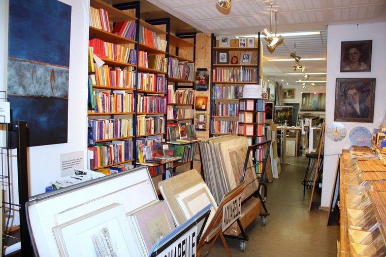 Bücherregale mit Kunst- und Fachliteratur, Portraitgemälde an der Wand