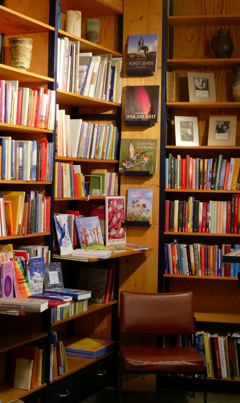Hohe Bücherregale mit Kunst- und Fachliteratur, davor ein Lederstuhl