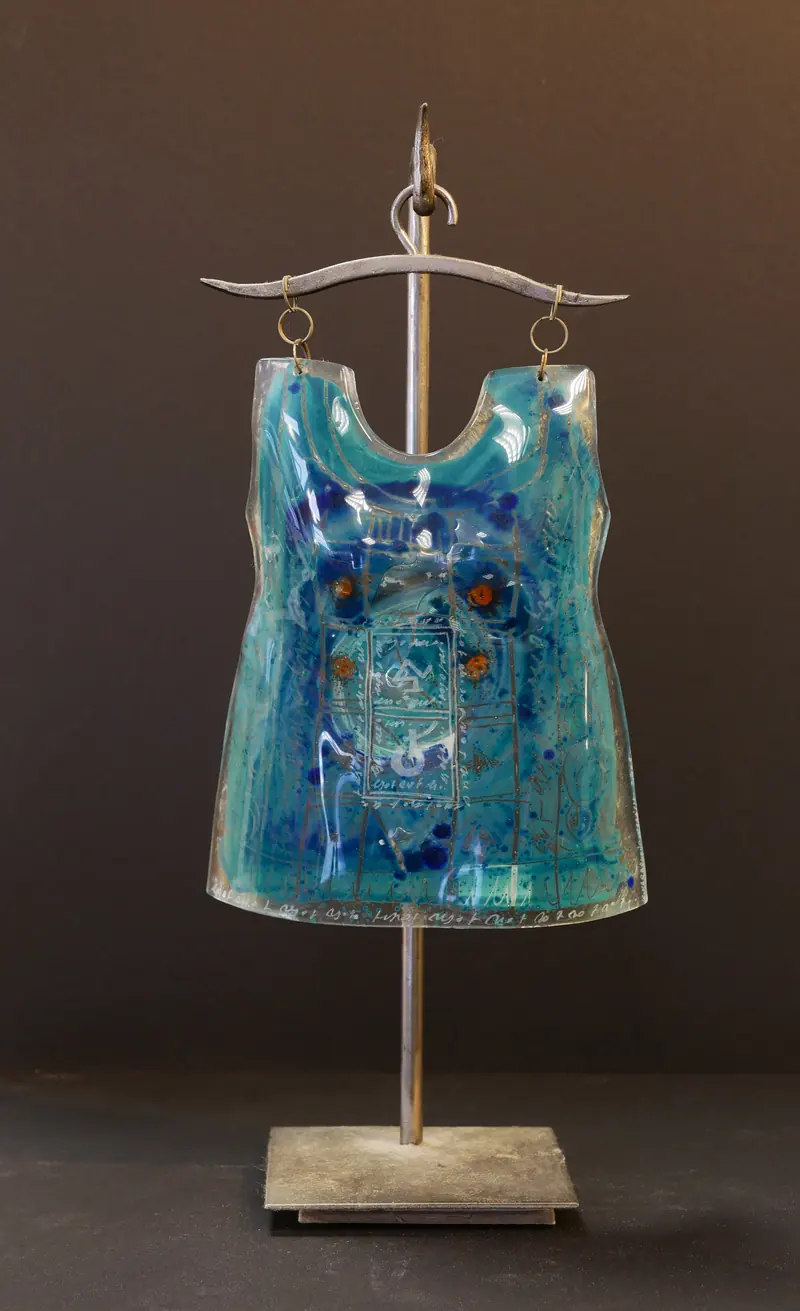 Glasskulptur in Form eines türkisblauen Kleides an einem Metallbügel